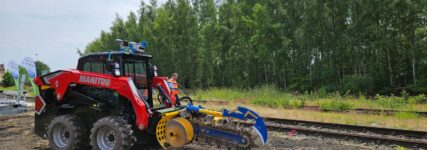 Kettenlader verlegt bei laufendem Bahnbetrieb